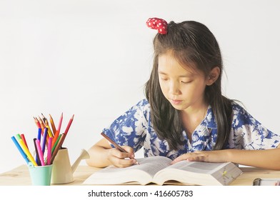 Asian Lovely Child Is Reading A Book