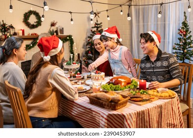 Asian lovely family celebrating Christmas party together in house. Attractive parents and relatives having dinner eating foods to celebrate holiday Thanksgiving, X-mas eve on dining table at home. - Powered by Shutterstock