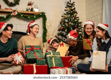 Asian lovely family exchanging presents during Christmas party at home. Attractive happy people holding gift box, celebrate holiday thanksgiving, xmas eve tradition in living room in house together. - Powered by Shutterstock