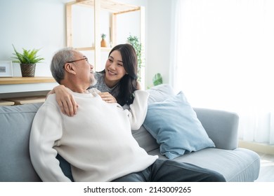 Asian Lovely Family, Young Daughter Greeting And Hugging Older Father. Attractive Woman Granddaughter Visit Senior Elder Mature Man In House Enjoy Spend Leisure Time Together In Living Room And Smile.