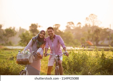 asian lovely muslim couple riding a bike together - Powered by Shutterstock