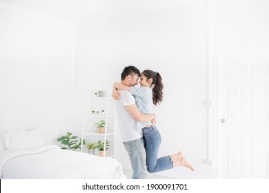 asian lover in white room, asian man carry asian woman, they hug and kiss together, they feeling happy and smile, honeymoon happiness