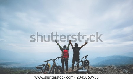  Asian lover woman and man Travel Nature. Travel relax ride a bike Wilderness in the wild. Standing on a rocky cliff. Thailand 