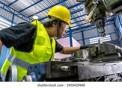 Asian Machinist In Safety Suit Operating The Professional Lathes In Metalworking Factory, Lathe Grinding Metalworking Industry Concept