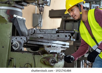 Asian Machinist In Safety Suit Operating The Professional Lathes In Metalworking Factory, Lathe Grinding Metalworking Industry Concept