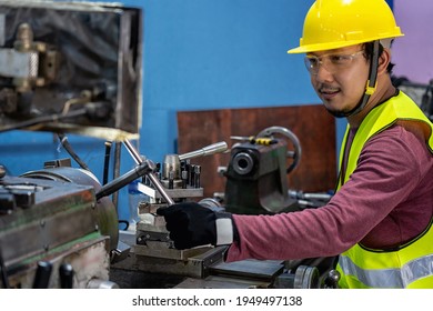 Asian Machinist In Safety Suit Operating The Professional Lathes In Metalworking Factory, Lathe Grinding Metalworking Industry Concept