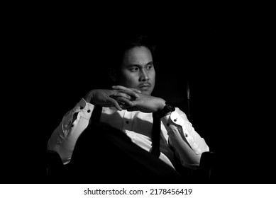 Asian Mafia Boss Sitting In A Chair With A Black Background