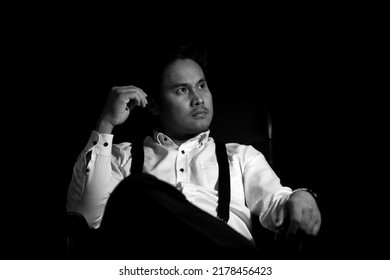 Asian Mafia Boss Sitting In A Chair With A Black Background