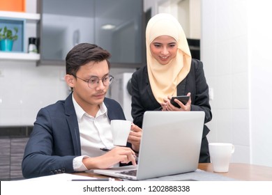 Asian Malay Executive Working At Home With Laptop Discussing