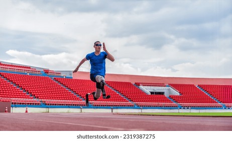 Asian male athlete with prosthetics runs at full speed, demonstrating a powerful practice on stadium track - Powered by Shutterstock