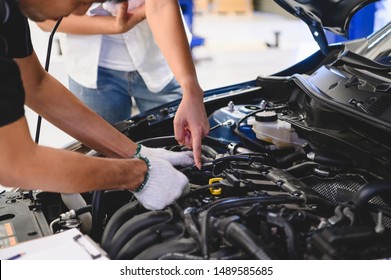 Asian Male Auto Mechanic Examine Car Engine Breakdown Problem In Front Of Automotive Vehicle Car Hood With Female Customer. Safety Technical Inspection Care Check Service Maintenance For Road Trip