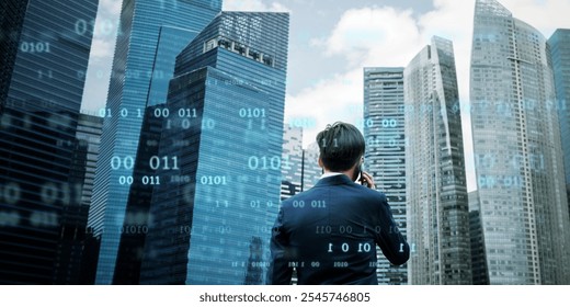 Asian male in business attire, standing in front of skyscrapers with digital code overlay. Business, technology, and cityscape concept. Man using phone surrounded by modern office buildings. - Powered by Shutterstock