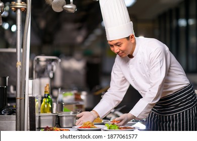 Asian Male Chef Presenting Dish Kitchen Stock Photo (Edit Now) 2027295107