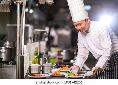 Asian Male chef presenting the dish in the kitchen. Selective focus. - Powered by Shutterstock