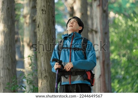 Asian male climber looking around in the mountain
