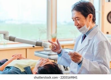 Asian Male Dentist And Male Patient