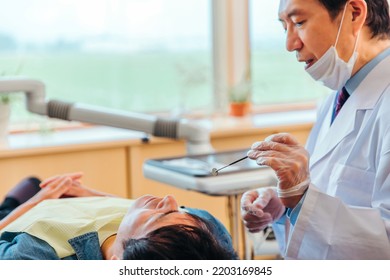 Asian Male Dentist And Male Patient