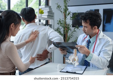 Asian male doctor explaining bone x-ray examination film to patient Radiographs of the arm bones, joints, and spine body organs treatment concept Diagnosis. - Powered by Shutterstock