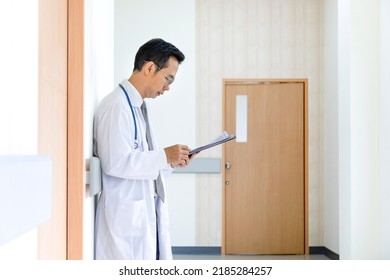 Asian Male Doctor Is Looking At The Patient Medical Record After Pay A Ward Visit For The Better Healing Examination And Future Nursing Care Plan Treatment Concept