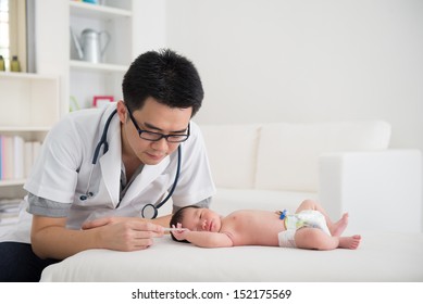 Asian Male Doctor And Newborn Baby On The Clinic 