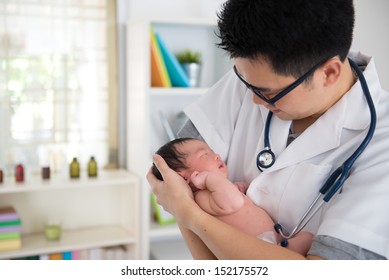 Asian Male Doctor And Newborn Baby On The Clinic 