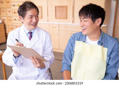 Asian Male Doctor And Patient (dentist)