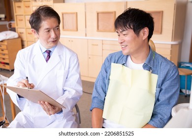 Asian Male Doctor And Patient (dentist)