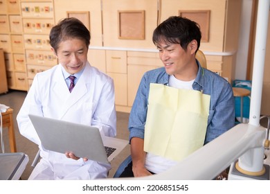 Asian Male Doctor And Patient (dentist)