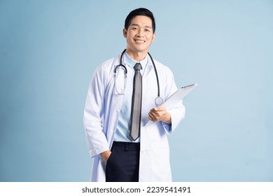 Asian male doctor portrait on blue background - Powered by Shutterstock