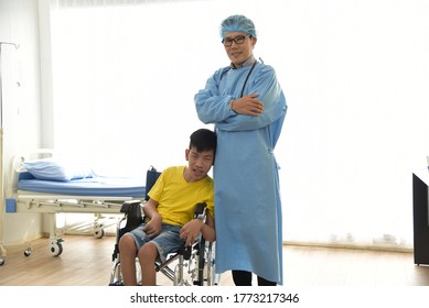 An Asian Male Doctor Taking Care And Look After Disabled Boy Patient /cripple Who Can Not Help Himself Sitting On Wheelchair In Hospital/Disability