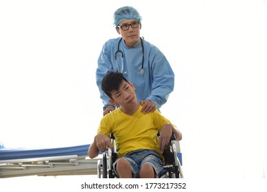 An Asian Male Doctor Taking Care And Look After Disabled Boy Patient /cripple Who Can Not Help Himself Sitting On Wheelchair In Hospital/Disability