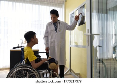 An Asian Male Doctor Taking Care And Look After Disabled Boy Patient /cripple Who Can Not Help Himself Sitting On Wheelchair In Hospital/Disability