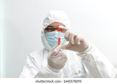 Asian Male Doctor Wearing Protective Suits Holding A Positive Blood Test Result For The New Rapidly Spreading Coronavirus (nCoV, Covid-19). International Standard Biological Laboratory Concept.