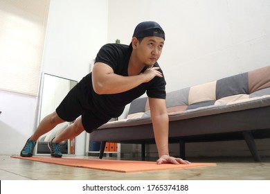 Asian Male Doing Exercise At Home To Stay Healthy On New Normal Lifestyle, Indoor Home Workout Concept, Shoulder Tap Push Ups Plank Position