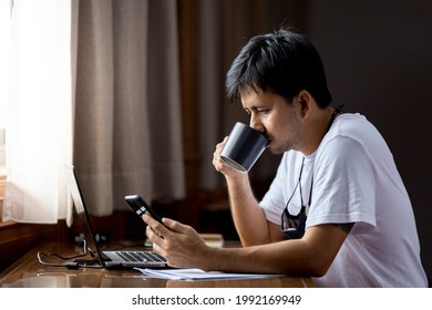 Asian Male Drinking Coffee Use A Smartphone At Home 