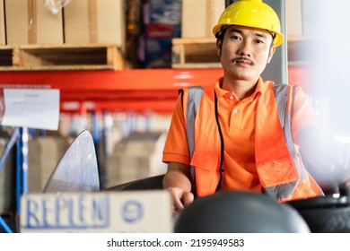 Asian Male Driver Sitting Driving On Forklift Truck Looking At Camera In The Warehouse Distribution. Men At Work For Logistic Shipping Career.