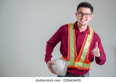 Asian male engineer or architect with a white helmet on a white background standing in a photo studio. Asian workers work on building projects. happy smiling worker - Powered by Shutterstock