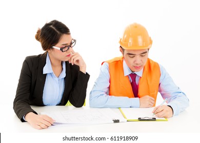 Asian Male Engineer Discuss Work With Business Woman Isolated On White Background. Male Engineer With Red Tie, Blue Shirt And Safety Hat And Safety Jacket Talking To Woman In Black Suit With Notepad.