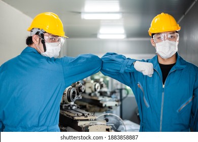 Asian Male Factory Worker In Medical Face Mask Elbow Bump Greeting In New Normal Lifestyle With Colleague For Social Distancing To Prevent Coronavirus, Healthcare For Industrial People. Men At Work