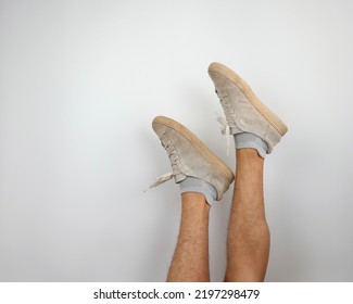 Asian Male Feet Wearing Old White Sneakers  Isolated Over White Background                    