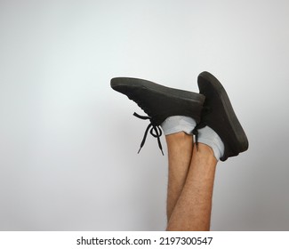 Asian Male Feet Wearing Old Black Sneakers Isolated Over White Background