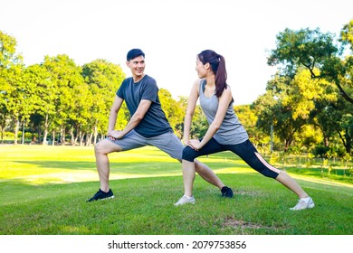 Asian male and female couple Exercise in the outdoor park in the morning. They are healthy, smiling and happy. fitness concept, health care - Shutterstock ID 2079753856