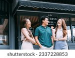 Asian Male and Female Friends Bonding on the Street in Front of Cozy Cafe. Young Adult Friends Talking and Having a Good Time Together. Youthful Urban Lifestyle Concept