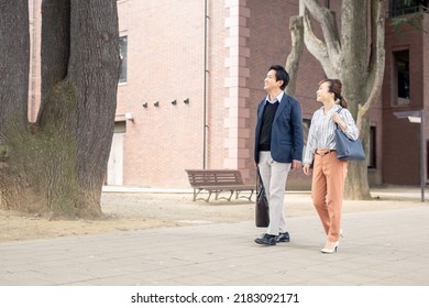 Asian Male And Female Office Workers Walking In The City