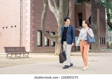Asian Male And Female Office Workers Walking In The City