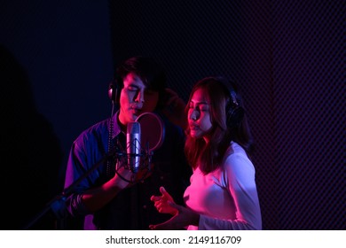 Asian Male And Female Singers Recording In The Studio.