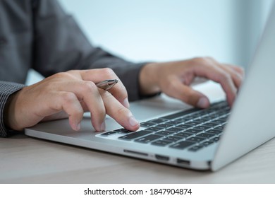 asian male finance staff is typing on keyboard to check email and investment reports, investment ideas and audits. Performance tracking