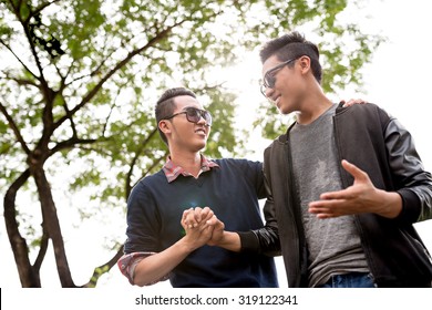 Asian Male Friends Talking Outdoors