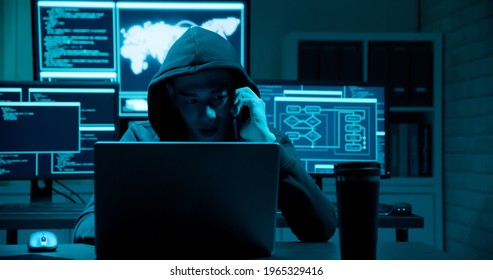 Asian male hacker is extorting on the phone with computer