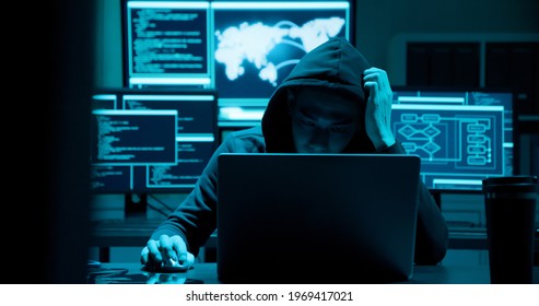 Asian male hacker is serious and angry with computer